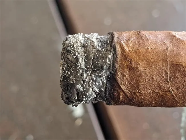 Points blancs sur la cendre d’un cigare